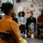 Pessoa em ambiente social sem receber atenção, representando exclusão e falta de acolhimento